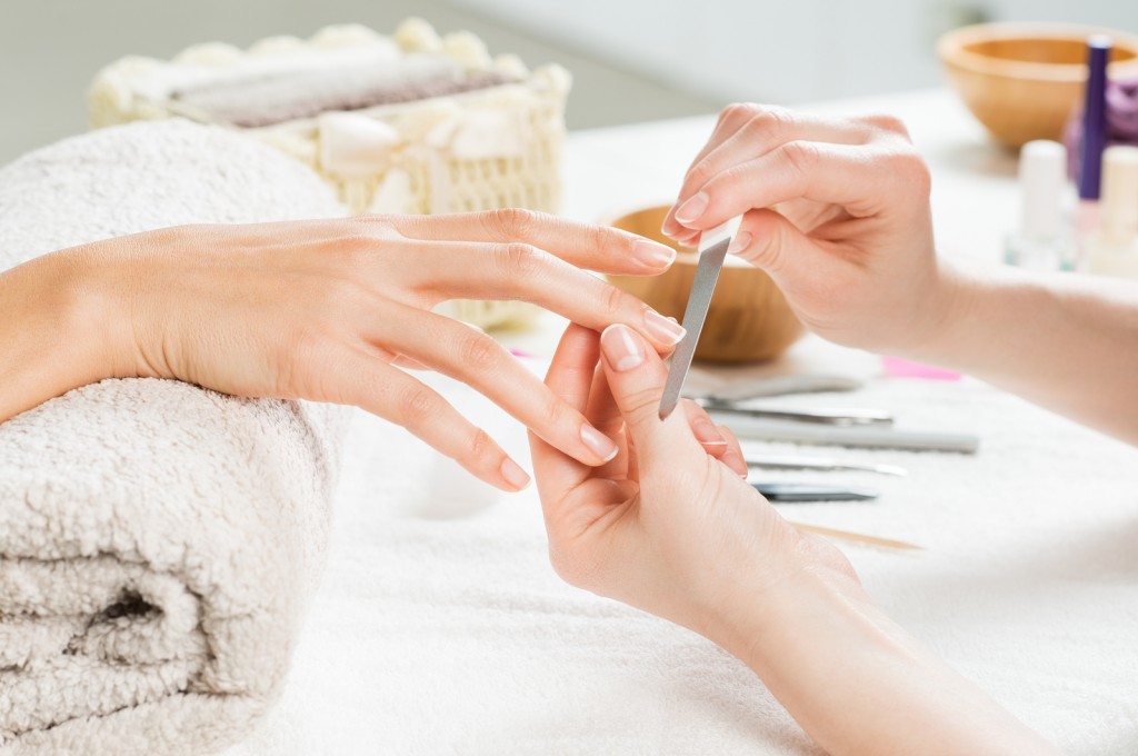 Closeup shot of a woman in a nail salon receiving a manicure by