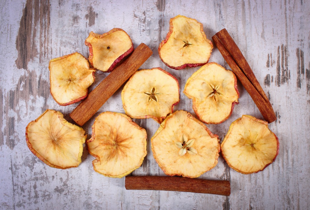 Slices Of Dried Apple And Cinnamon Sticks On Old Rustic Wooden B