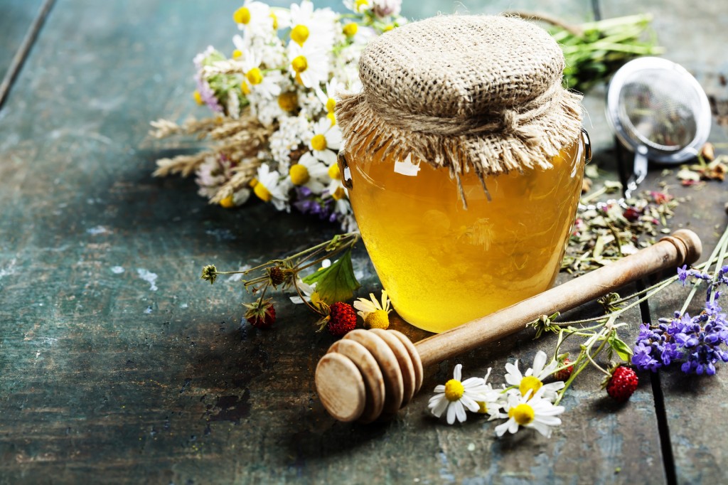 Honey and Herbal tea on wooden background - summer, health and o